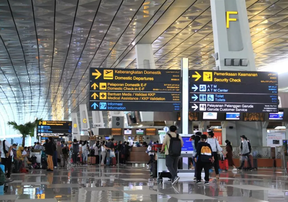 Driver profesional menjemput penumpang di bandara dengan mobil nyaman.