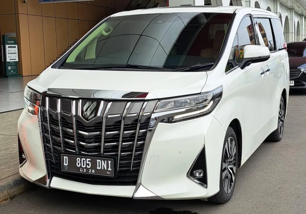 Toyota Alphard hitam terparkir di depan resort Lembang untuk liburan mewah. Sewa Alphard Liburan Bandung Premium